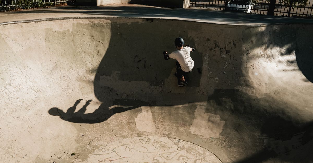 Skater bajando por la pared curva de un bowl de cemento